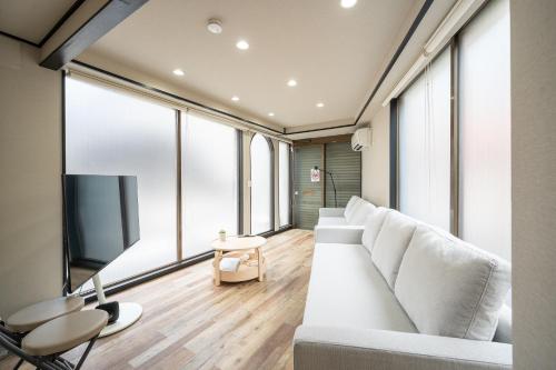 a living room with a white couch and large windows at Familia Heiwajima in Tokyo
