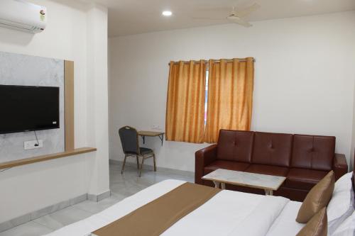 a hotel room with a bed and a couch at Hotel Vaarahi Chanda Nagar, Near Hitech City in Hyderabad