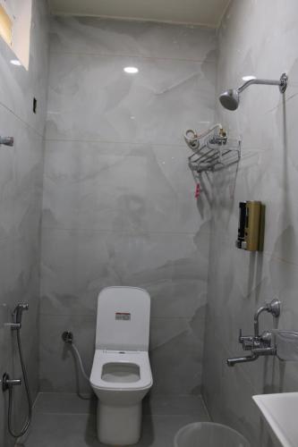 a white bathroom with a toilet and a sink at Hotel Vaarahi Chanda Nagar, Near Hitech City in Hyderabad