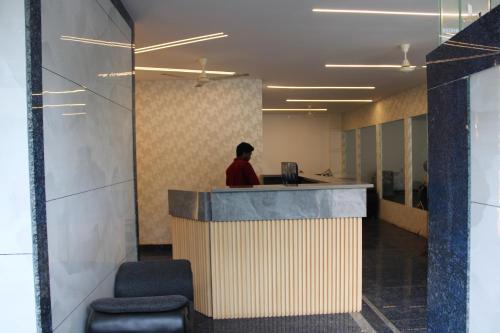 a man sitting at a counter in an office at Hotel Vaarahi Chanda Nagar, Near Hitech City in Hyderabad