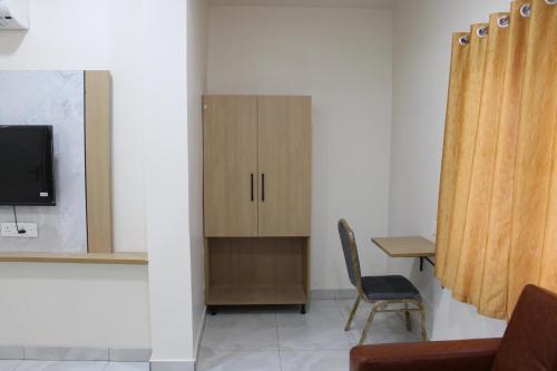 a living room with a cabinet and a chair at Hotel Vaarahi Chanda Nagar, Near Hitech City in Hyderabad