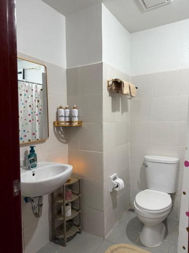 a bathroom with a white toilet and a sink at Willow Nest in Bacolod