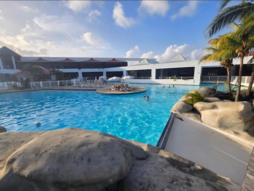 a pool at a resort with people in it at Le Colibri in Saint-François