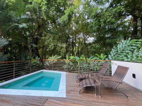 a deck with two chairs and a swimming pool at Elan at Ballena Beach in Uvita