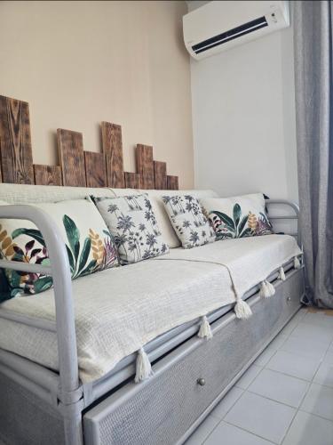 a couch with pillows on it in a room at Le Colibri in Saint-François