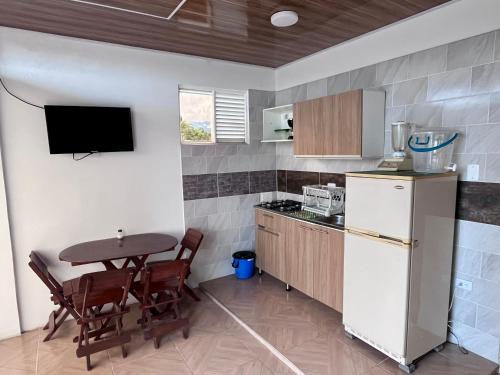 uma cozinha com uma pequena mesa e um frigorífico em Apartaestudio, fresco y cómodo em Acacías