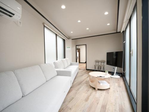 a living room with a white couch and a tv at Familia Heiwajima - Vacation STAY 16949 in Tokyo