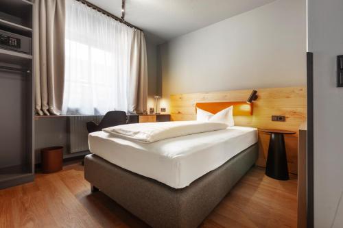 a hotel room with a bed and a television at Hotel am Jakobsmarkt in Nuremberg