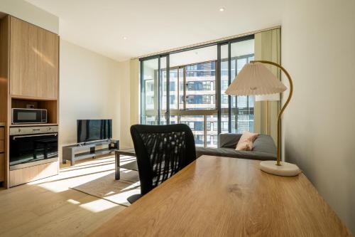 シドニーにあるLuxury studio unit in Macquarie Parkのテーブルとソファのあるリビングルーム