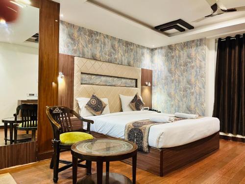 瓦拉纳西Trimrooms Banaras Station的一间卧室，里面有一张床、一张桌子和一把椅子