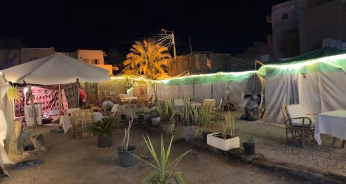 a group of tents with tables and chairs at night at Muhra Camp in Siwa