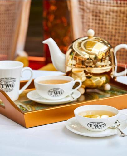 a tray with two cups of tea and a teapot at Chateau Royal Beach Resort & Spa, Noumea in Noumea