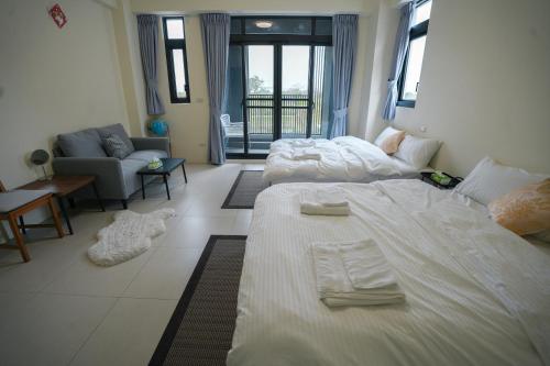 a bedroom with two beds and a living room at Yuejin Port B&B in T'u-k'u