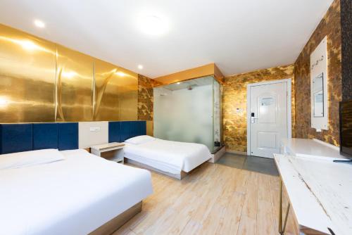 a hotel room with two beds and a bathroom at Hello Light Hotel Hankou Railway Station Flagship Store in Hankou Zhan
