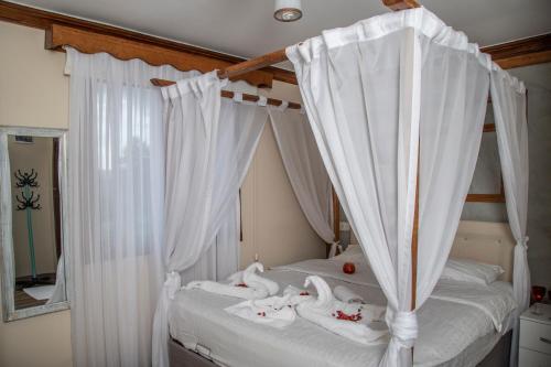 a bedroom with a canopy bed with white curtains at Danzot Tatil Köyü ve Restoran in Artvin