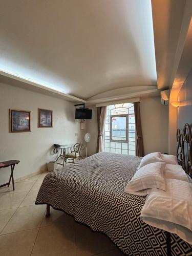 a bedroom with a large bed and a window at Hotel Plaza Ejecutivo in Tepatitlán de Morelos