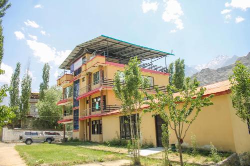 a yellow and pink building with a roof at Melody Hill Skardu in Skardu