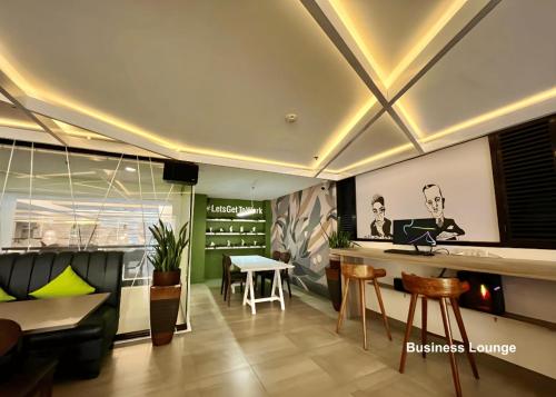 a room with a bar with a table and chairs at Citylight Hotel in Baguio