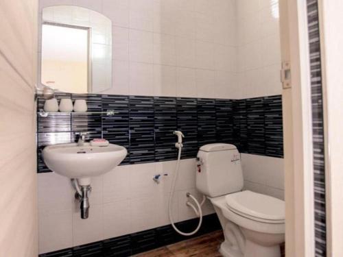 a bathroom with a toilet and a sink and a mirror at Klang Muang @ Nongkhai Hotel in Nong Khai