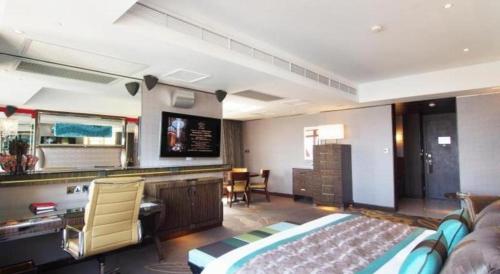 a hotel room with a bed and a desk at Grand Lisboa Macau in Macau