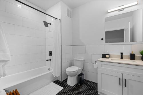 a white bathroom with a toilet and a sink at Charming 3bed Mill | Gym | Trail in Greenville