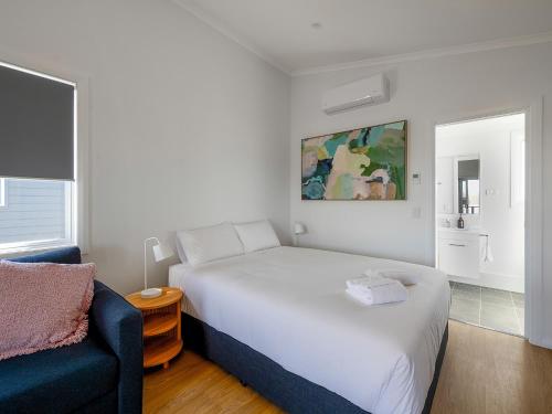 una camera con un letto bianco e un divano blu di BIG4 Casino Holiday Park a Casino