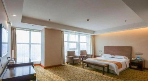 a hotel room with a bed and a couch at Jincheng Pacific Hotel in Jincheng