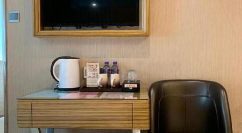a desk with a television and a chair in a room at Hong Thai Hotel in Macau