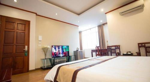 a bedroom with a bed and a tv in it at Gia Bao Hotel Bac Ninh in Hanoi