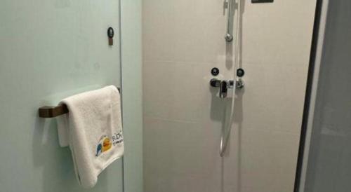 a shower in a bathroom with a white towel at Shanshui Trends Hotel-Bantian Dong Branch in Shenzhen