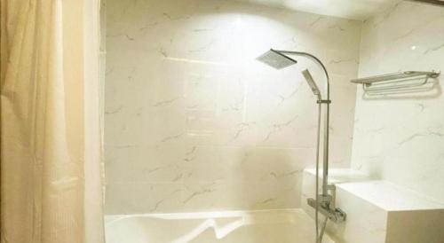 a white bathroom with a shower and a sink at Valaya Hotel Pathumthani in Pathum Thani