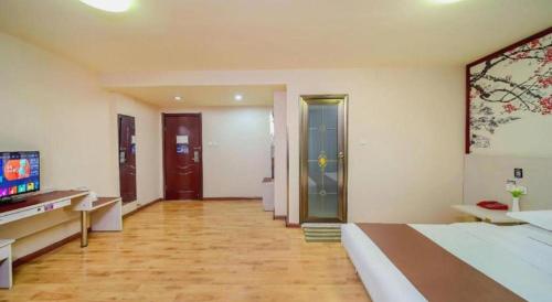 a large room with a bed and a television at Kunlun Leju Business Hotel Kaifeng Gulou in Kaifeng
