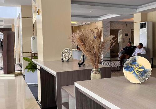 a lobby with a table with a vase of flowers at Hotel Mekkah Banda Aceh in Banda Aceh