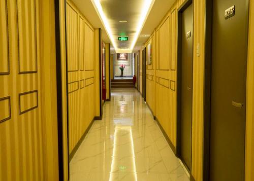 a hallway of a building with yellow walls and tile floors at Horizon Hotel in Olongapo