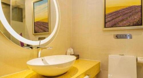 a bathroom with a bowl sink and a mirror at Lavande Hotel Yichang Railway East Station Branch in Yichang