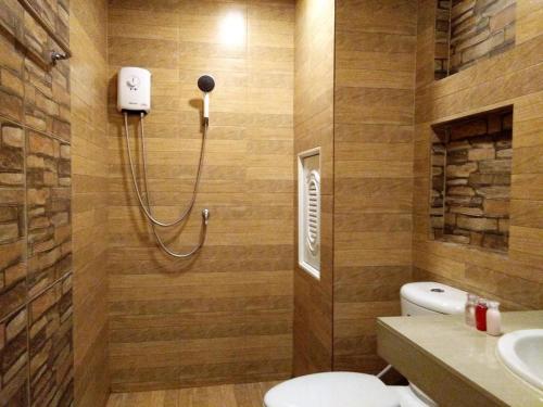 a bathroom with a shower with a toilet and a sink at The Vintage Residence in Ban Thung Sukla