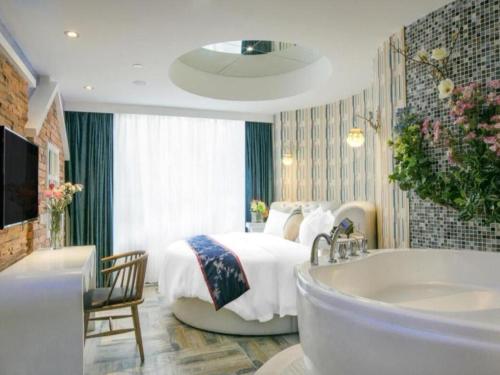 a bedroom with a bed and a bathtub and a tub at Vienna Hotel - Shenzhen Dongmen Hubei Metro Station in Shenzhen