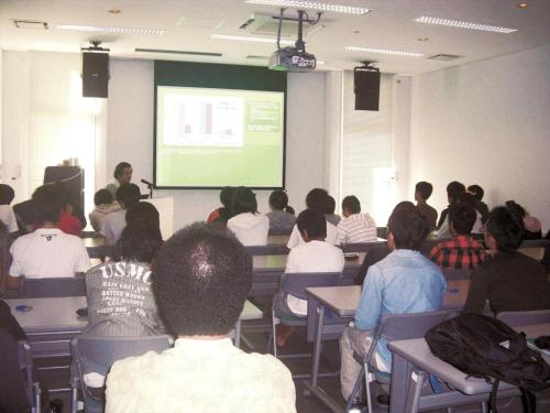 a group of people sitting in a classroom watching a presentation at Nature Miraikan in Naha