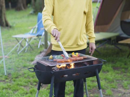 a man is cooking food on a grill at Nature Miraikan in Naha