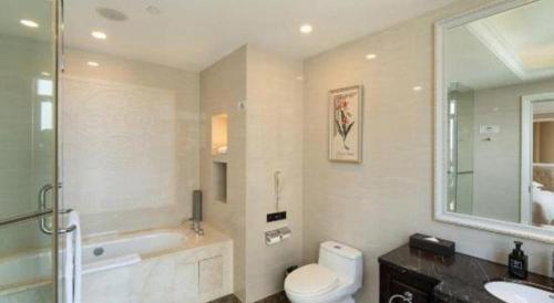 a bathroom with a toilet and a tub and a sink at Tongxiang Inspirock Hotel in Jiaxing