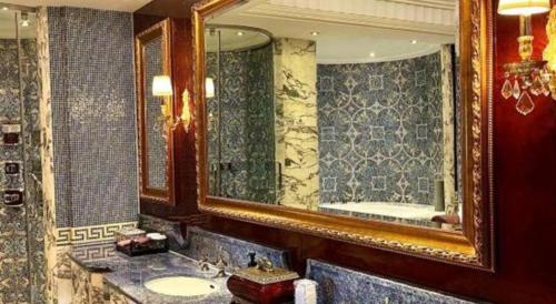 a bathroom with a sink and a large mirror at Tongxiang Inspirock Hotel in Jiaxing