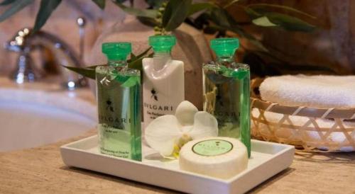two bottles of soap and a clock on a bathroom counter at Excellence Playa Mujeres- All Inclusive- Adults Only in Cancún