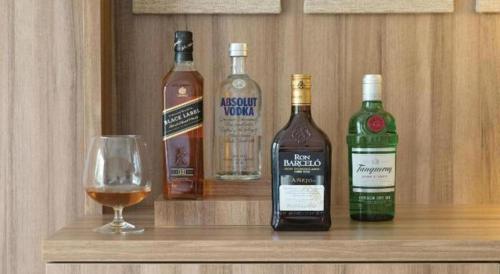 three bottles of wine and a glass on a shelf at Excellence Playa Mujeres- All Inclusive- Adults Only in Cancún
