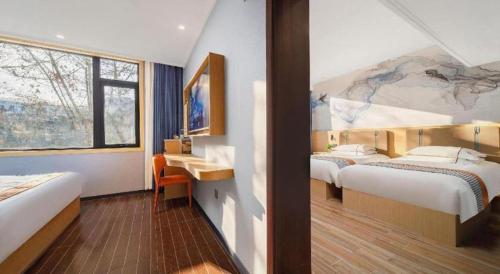 a hotel room with two beds and a painting on the wall at JIAN AI XI YUE HOTEL in Yiwu