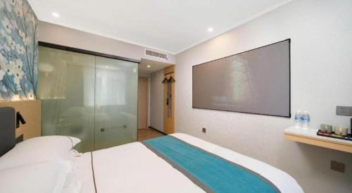 a bedroom with a bed and a large screen at JIAN AI XI YUE HOTEL in Yiwu