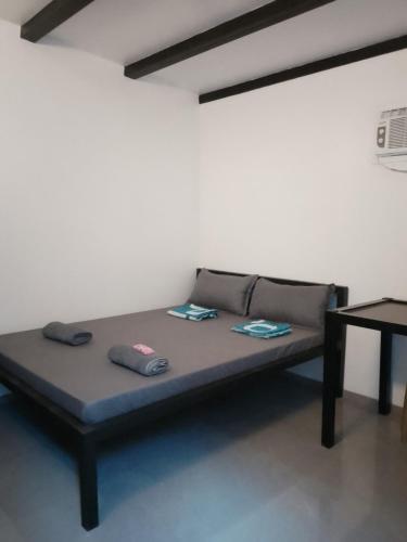 a bed with two pillows on it in a room at Shawe pension house in San Remigio