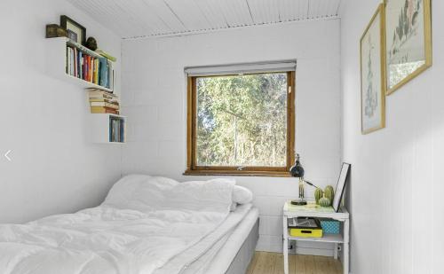 une chambre blanche avec un lit et une fenêtre dans l'établissement Holiday Home With Garden Near Tisvilde Beach, à Græsted