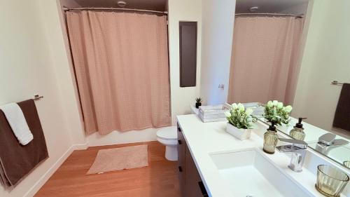 a bathroom with a white sink and a toilet at One Lux Stay - Hollywood in Los Angeles