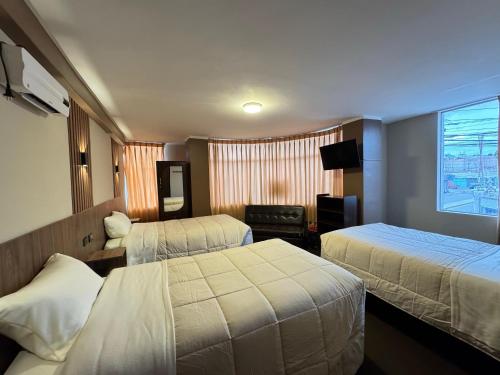a hotel room with two beds and a window at Hotel Posada de Belén in Espinar