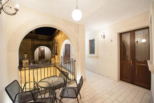 un couloir avec une table et des chaises dans un bâtiment dans l'établissement Li Curti, à Scorrano